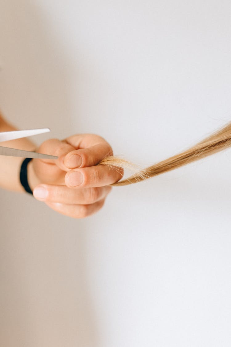 A Person Cutting A Hair