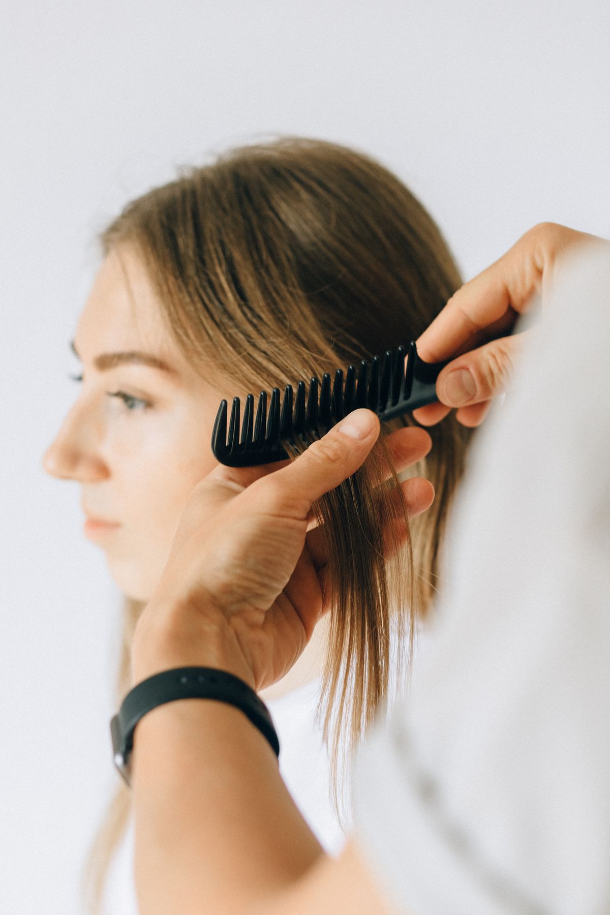 Mulher com cabelo sendo penteado cuidadosamente