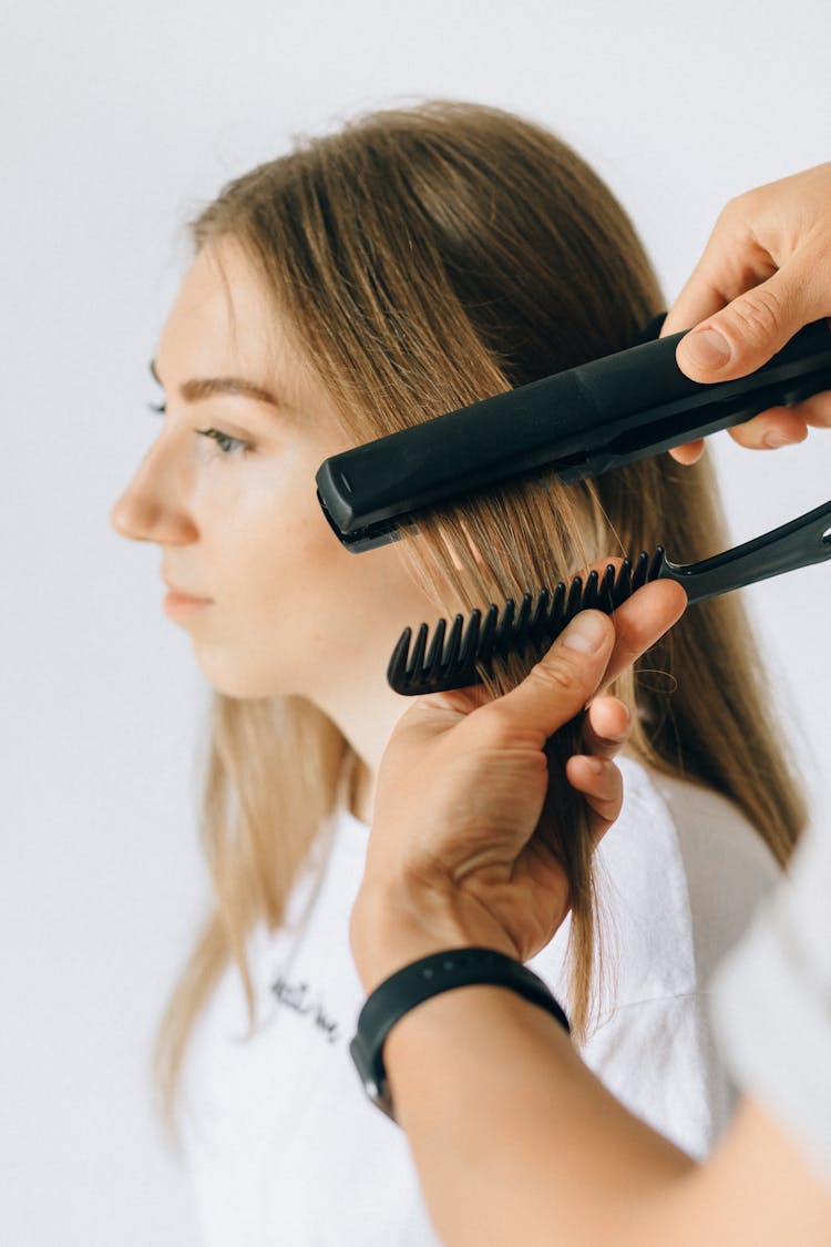 A Person Styling A Woman's Hair