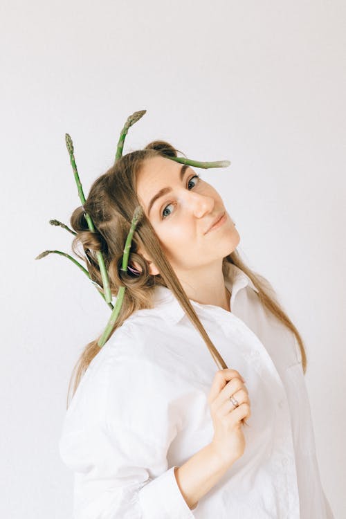 A Woman in White Long Sleeves with Asparagus on Her Hair