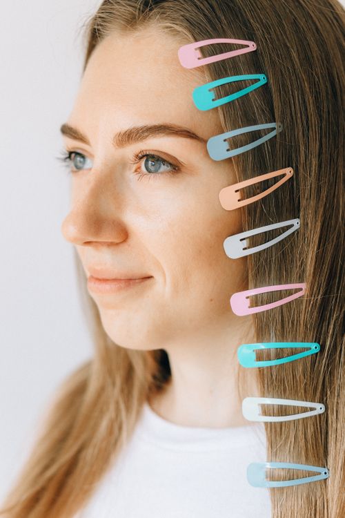 Free Profile of a woman with pastel hair clips in her hair, smiling softly. Stock Photo