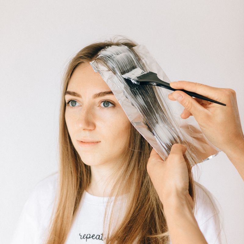 Colour being brushed onto lengths of hair