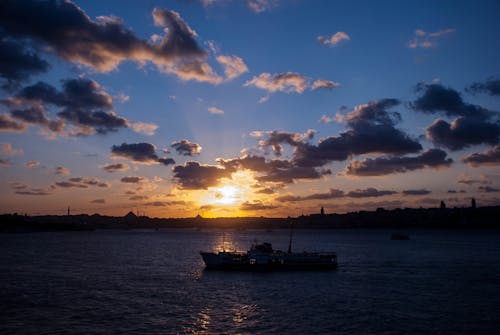 A Silhouette of a Boat on Sea during Sunset