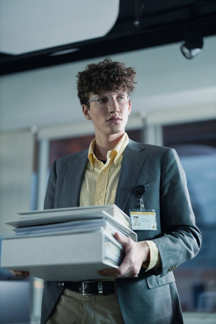 Man In Business Attire Carrying Folders Of Documents