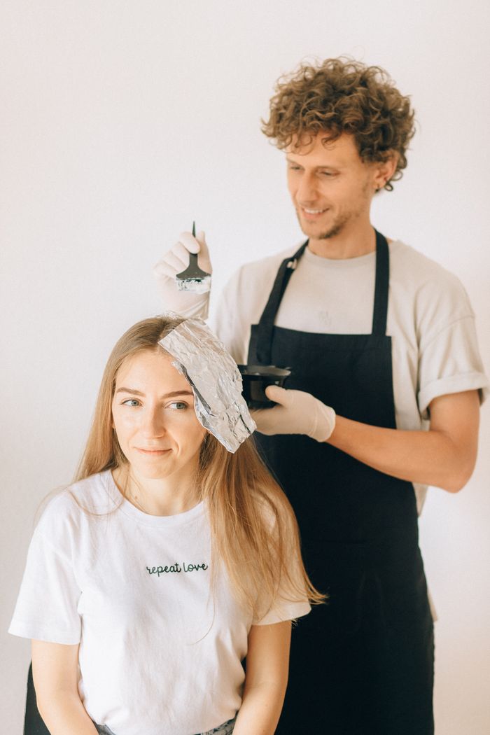 Cliente sorridente recebendo coloração com mechas