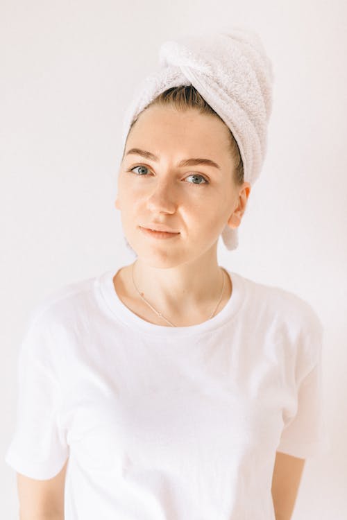 Free Woman in White Crew Neck Shirt Wearing White Towel Wrapped on Her Hair Stock Photo