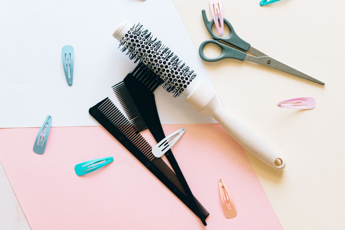 Hair brushes, combs, scissors and styling accessories arranged on a beauty workspace