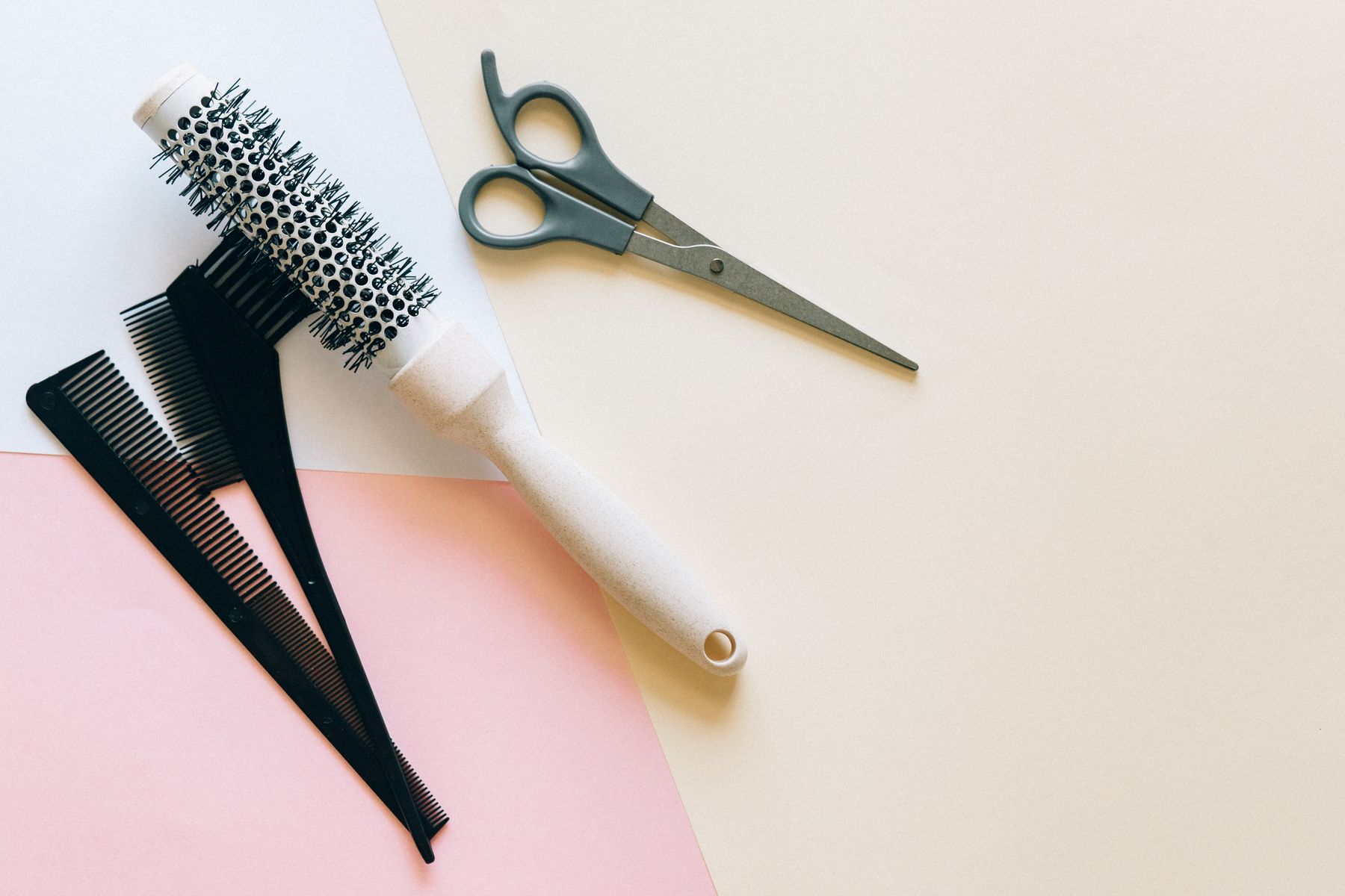Hair brushes, combs, and scissors arranged as professional styling tools