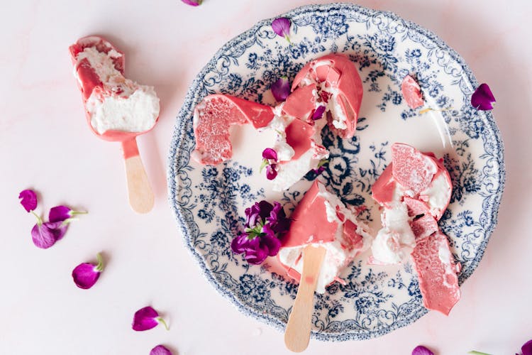 Melted Pink Ice Cream On Stick On Blue And Plate