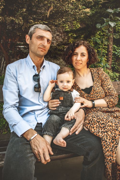 Free A joyful family portrait with parents and child on a sunny day in a park. Stock Photo