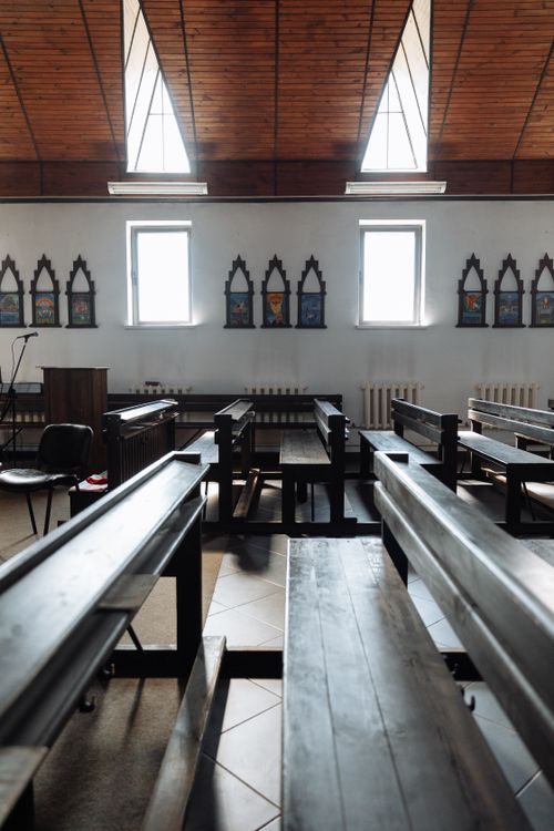 Free Well-lit church interior with wooden benches and high ceilings, featuring arched windows. Stock Photo