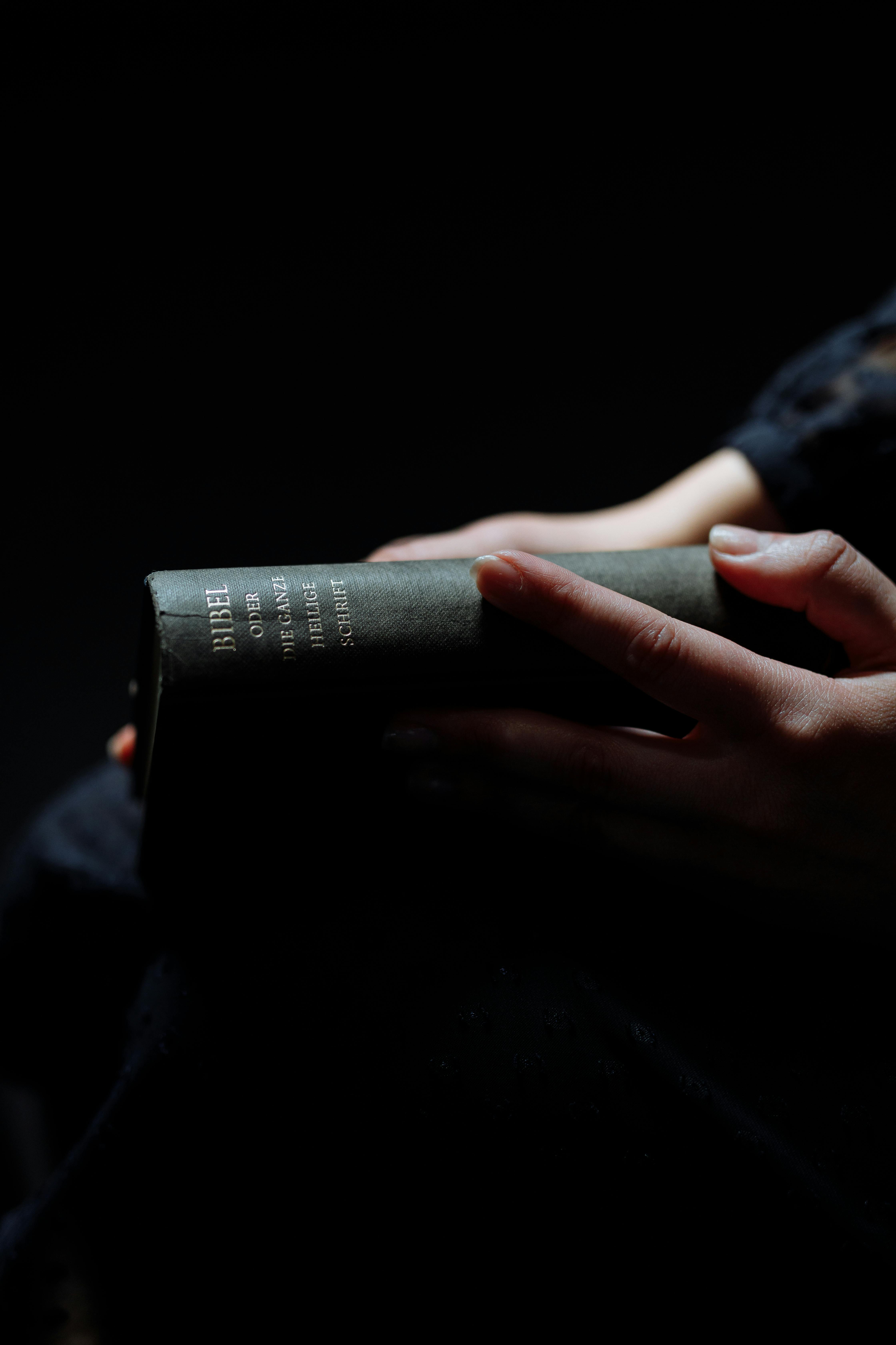 a person holding a black book