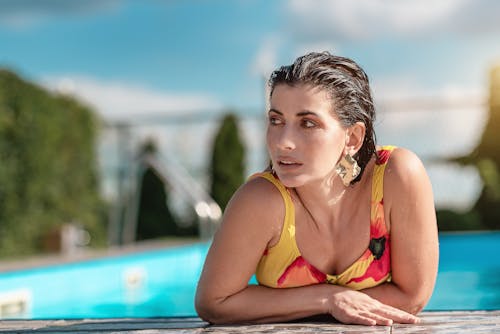 Selective Focus Photo of a Woman Looking Away at the Poolside