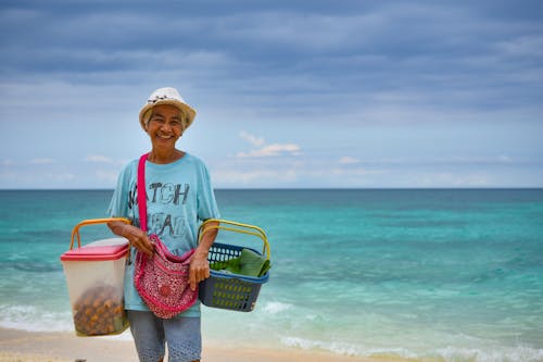 Happy Woman Holding Baskets on a Beach 