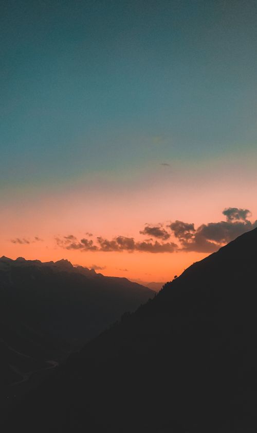 Free Capture the breathtaking view of a silhouetted mountain range at sunset, highlighting the dramatic sky and serene landscape. Stock Photo