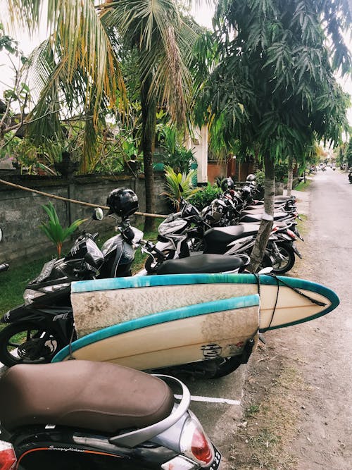 A Parked Motorcycle with a Broken Surfboard