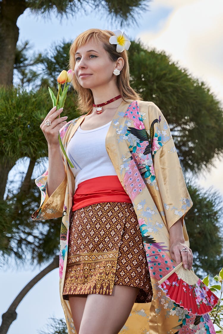 Woman In Traditional Clothes Smelling A Tulips