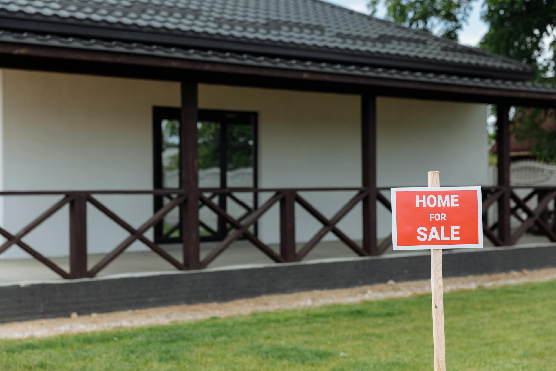 Property with Red and White Home for Sale Signage