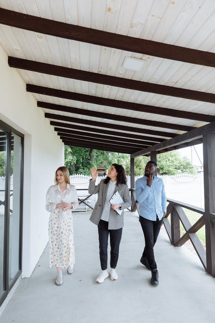 People With Real Estate Agent On Porch