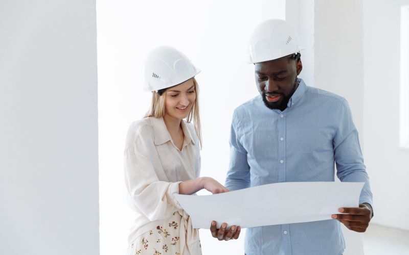 Two consultants reviewing approval documents and drawings together