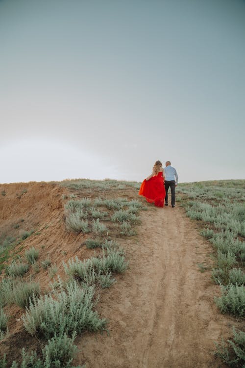 A Couple Walking on an Unpaved Pathway