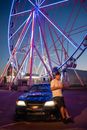 Man in White Shirt Standing Near Ferris Wheel during Night Time