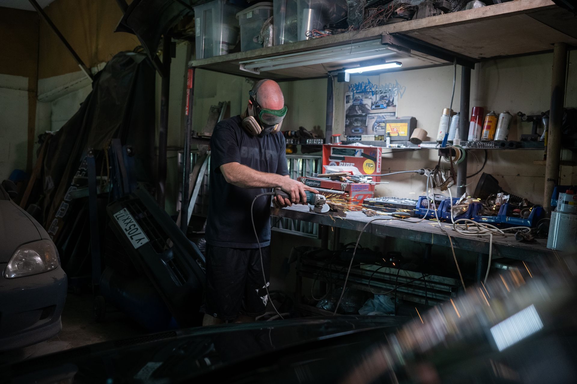 A Man in Black Shirt Wearing Safety Glasses while Using Grinder