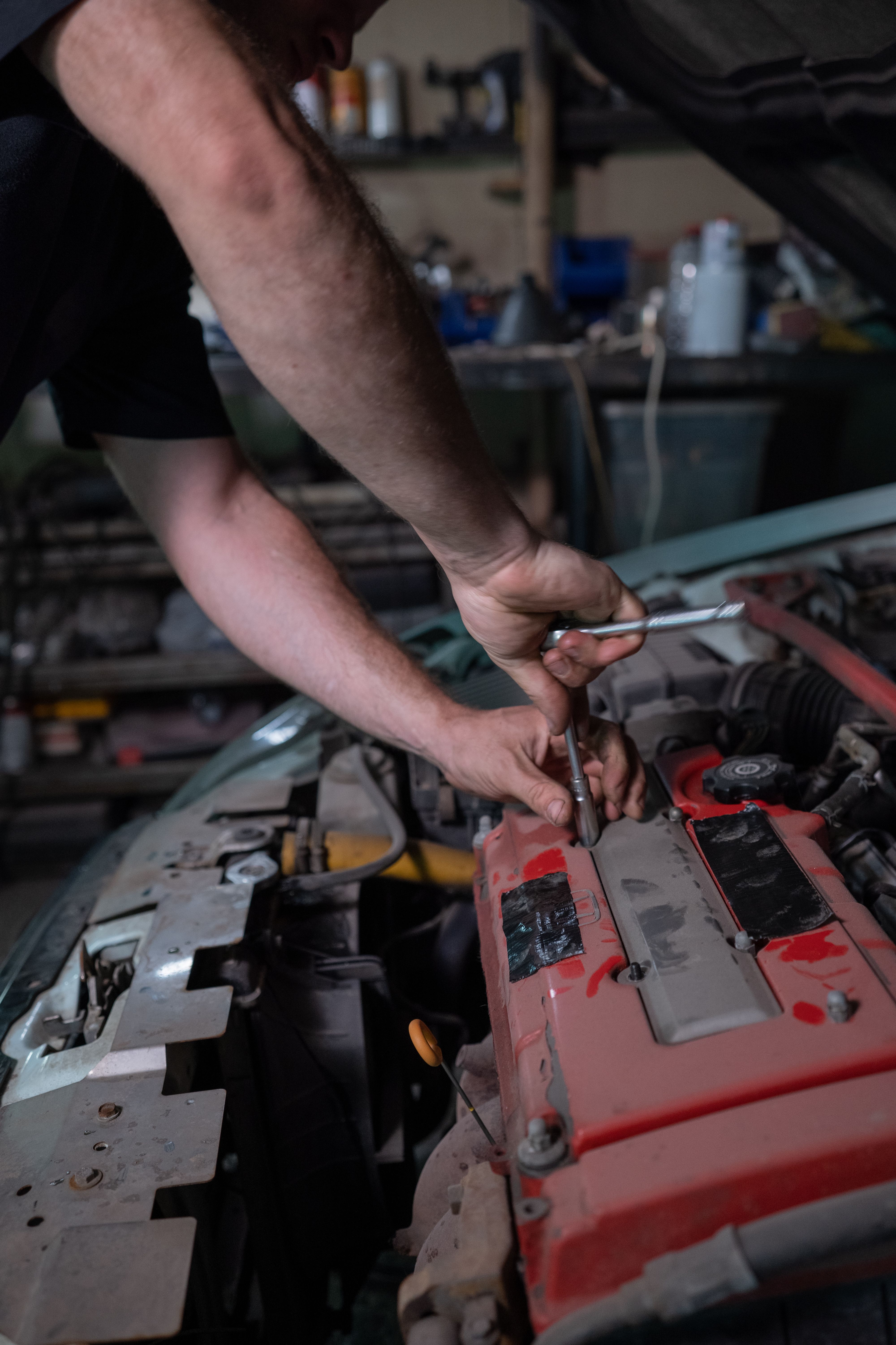 Stock reference image of a mechanic working under a bonnet
