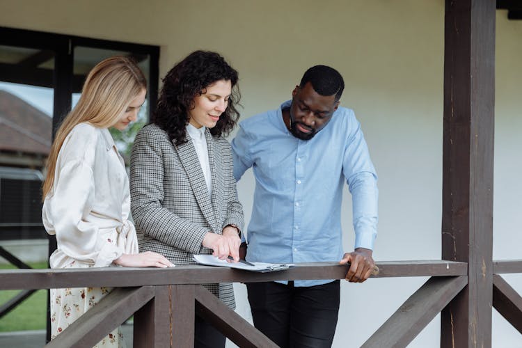 An Agent Discussing A Document To A Couple