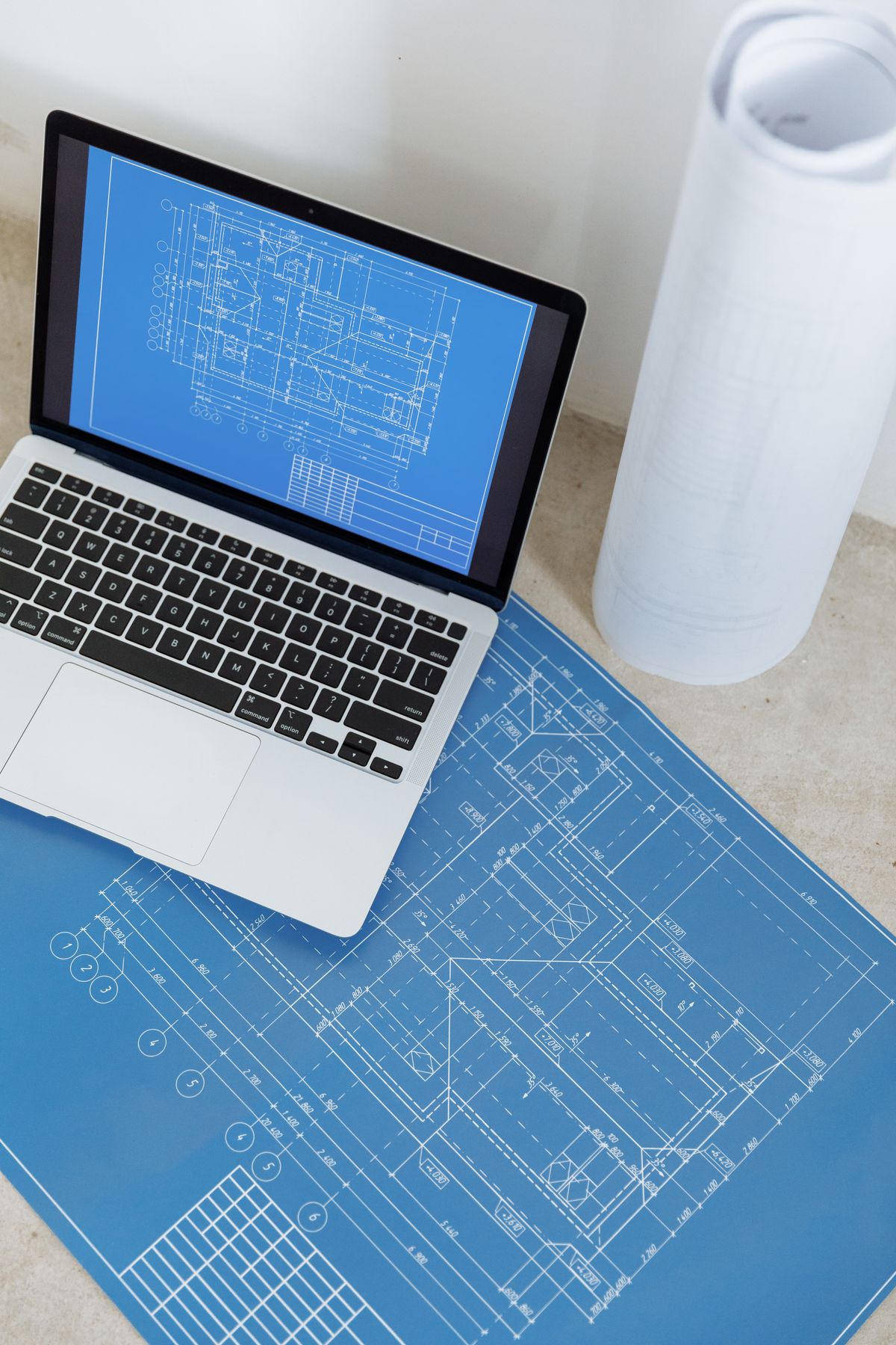 Laptop z cyfrowym rysunkiem technicznym i dokumentacją inżynieryjną