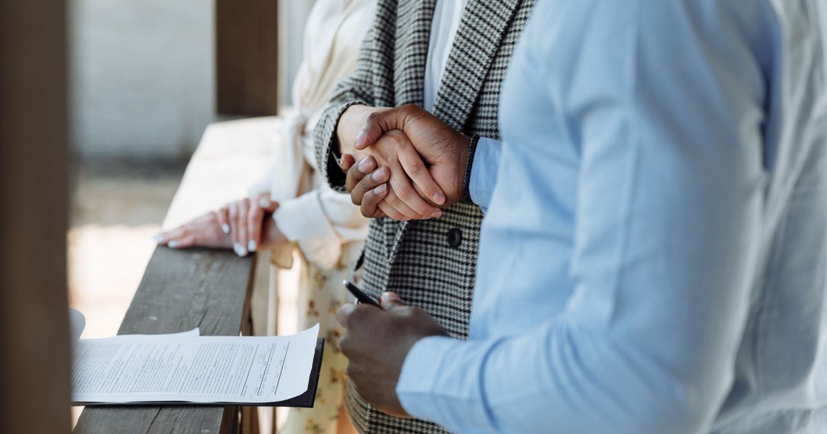 Two estate agents agreeing terms at a desk