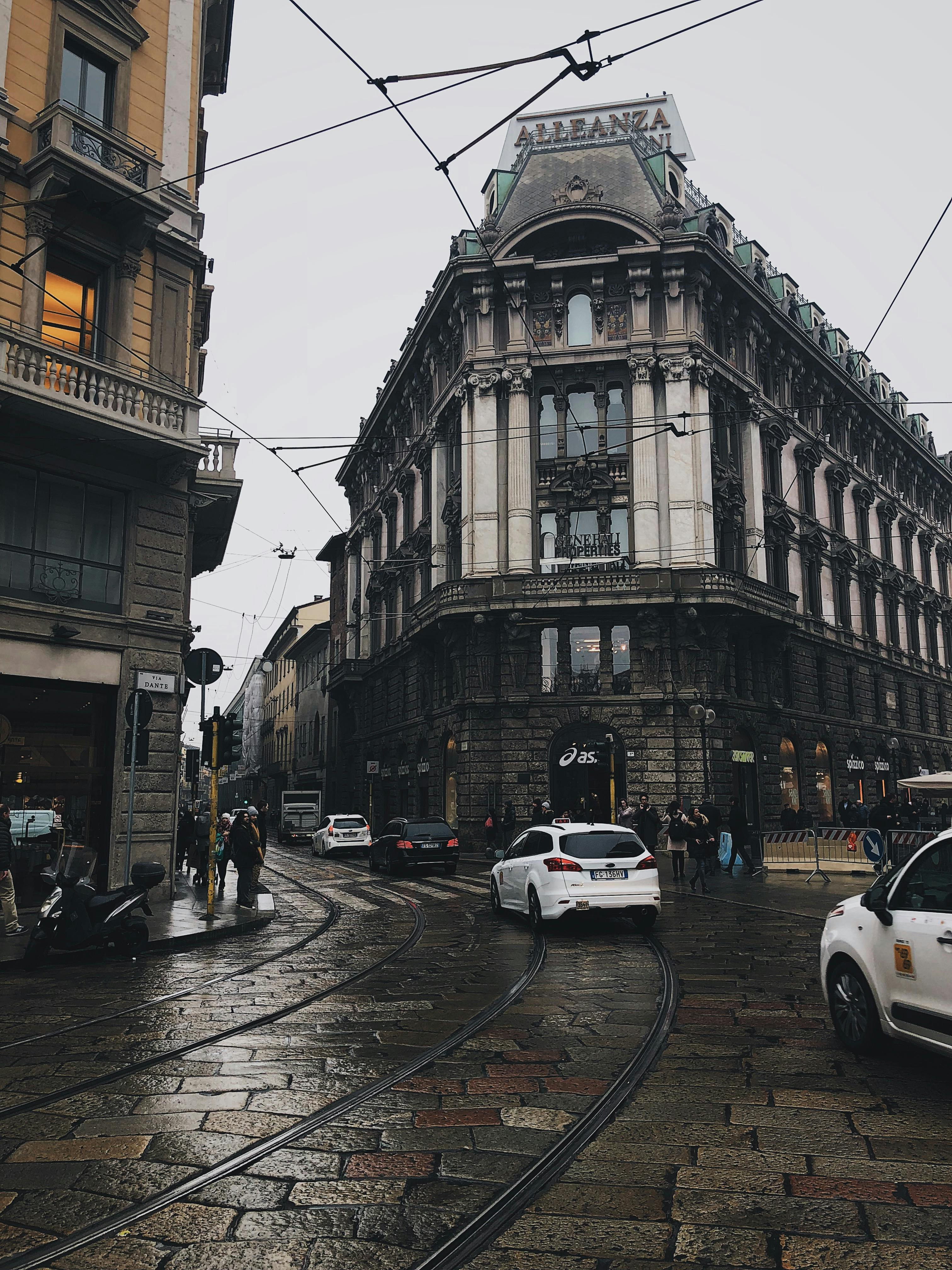 A rainy street scene in Milan, capturing historic architecture and urban life.