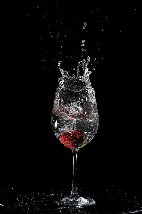 Free Water Splash from a Clear Wine Glass with Strawberry Inside Stock Photo