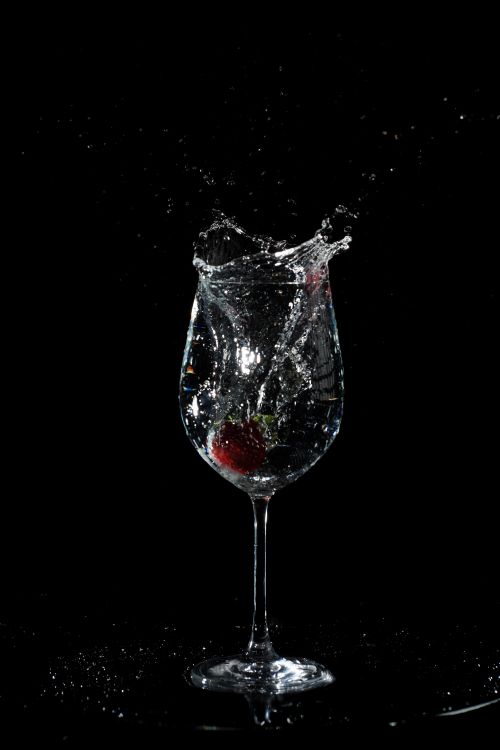 Free Dynamic capture of water splashing in a wine glass against a black background. Stock Photo