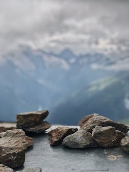 Close-up view of stones with a blurred mountainous backdrop, creating a serene natural landscape.
