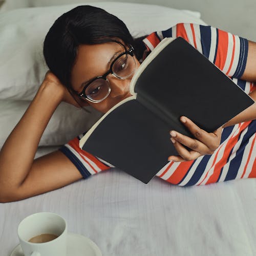 Free Woman in Striped Shirt Reading a Book Stock Photo