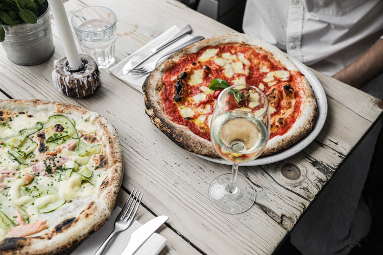 Plates Of Pizzas On A Wooden Table