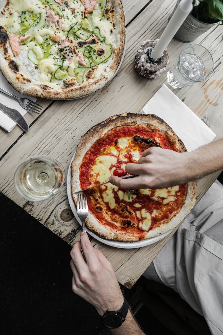 
A Person Slicing A Pizza