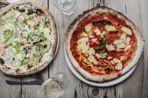 Free Two gourmet pizzas with unique toppings: salmon with zucchini and classic margherita. Stock Photo