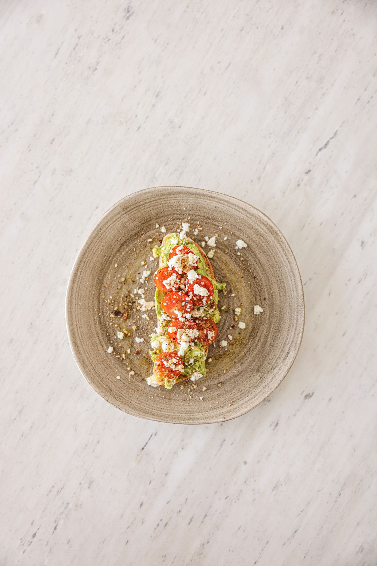 Torrada preparada com abacate, tomate e queijo