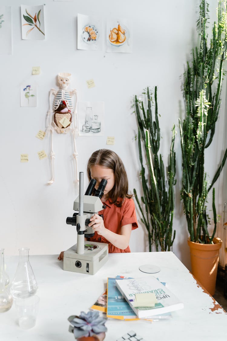 A Girl Using A Microscope