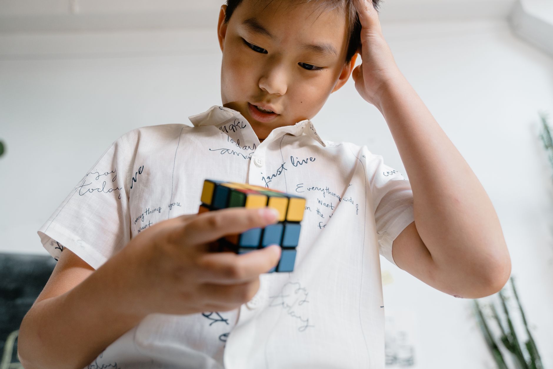 long covid brain fog recovery timeline — A child intensely focused on solving a Rubik's Cube, showcasing problem-solving skills.