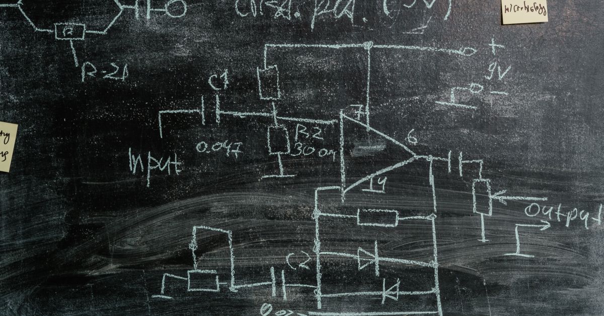 physics textbook with equations on chalkboard