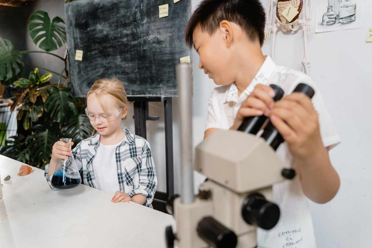 Children performing a science experiment with a microscope