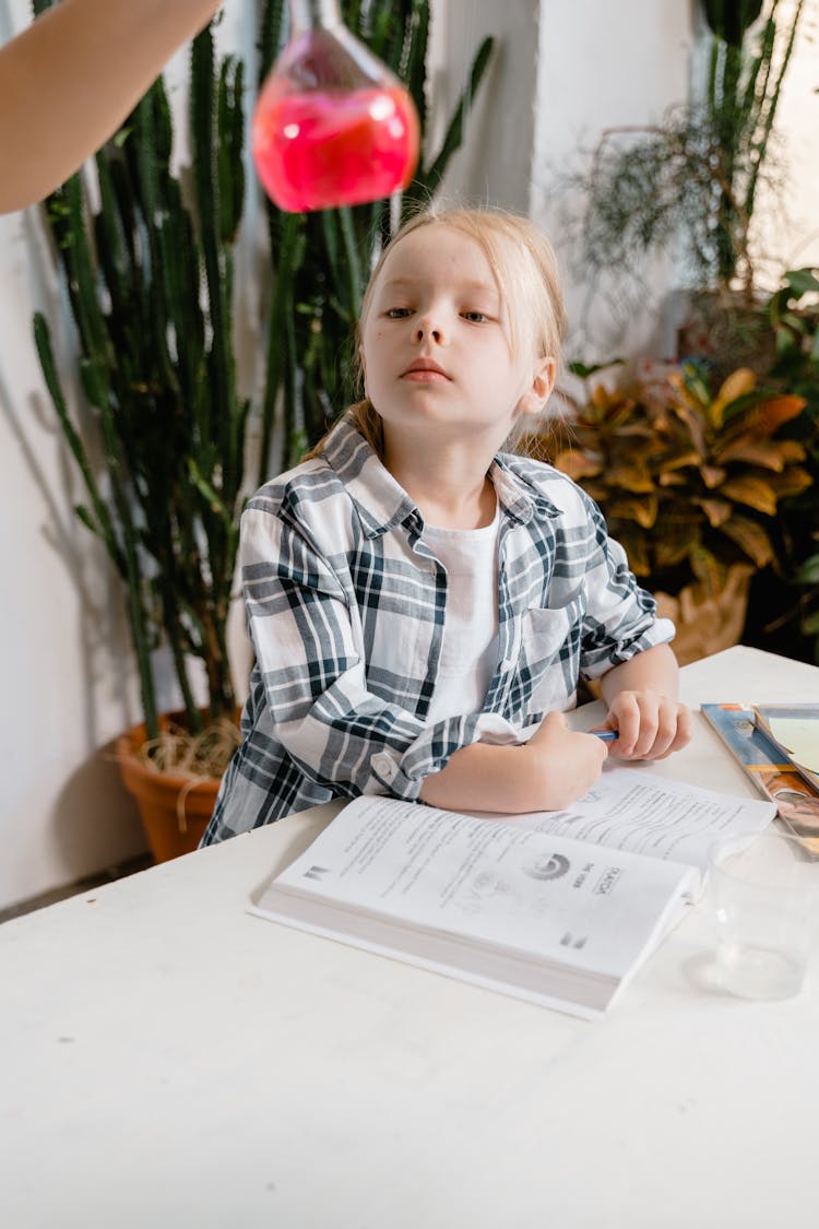 A Kid Looking At The Chemical In The Flask