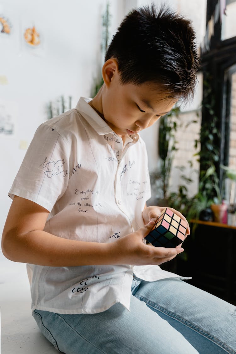 A Boy Playing With A Rubik's Cube