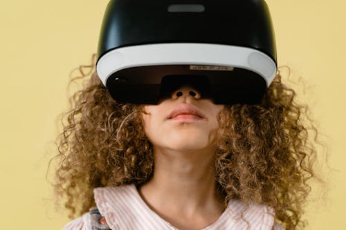 Close-Up Photo of a Girl with Curly Hair Playing in a Virtual Reality