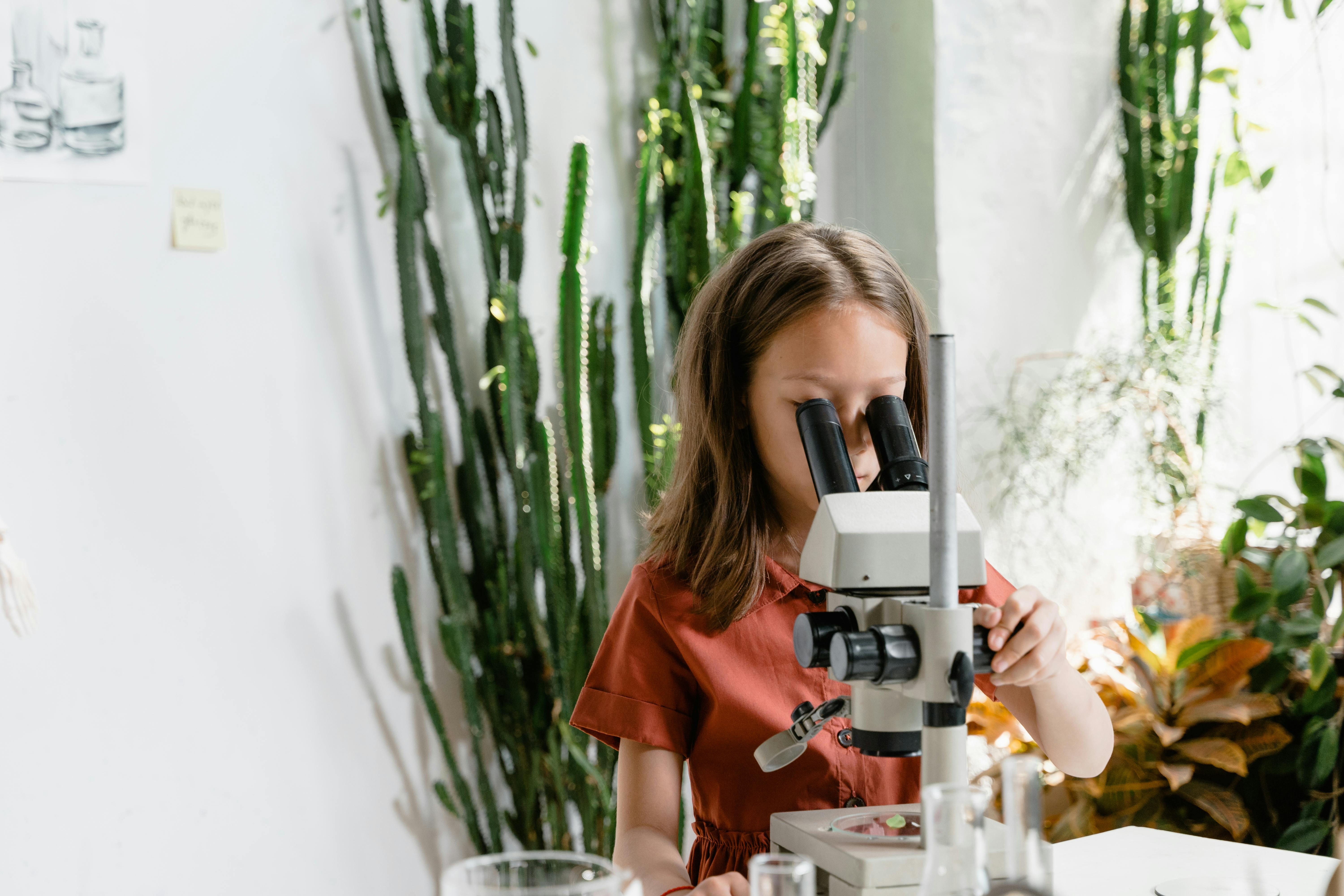 a girl looking at a microscope