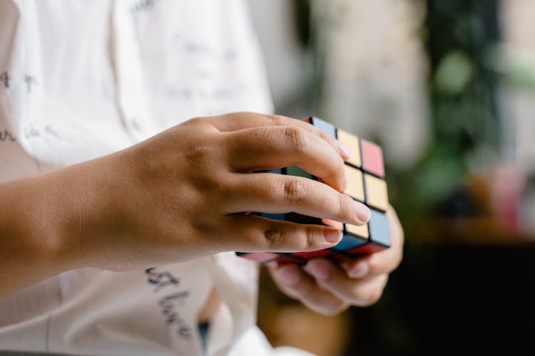 Close-Up Photo Of A Child Solving A Rubik's Cube