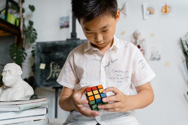 
A Boy Playing With A Rubiks Cube